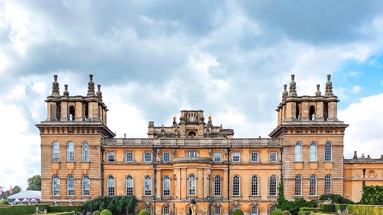 Woman walking in Blenheim Palace gardens surrounded by greenery