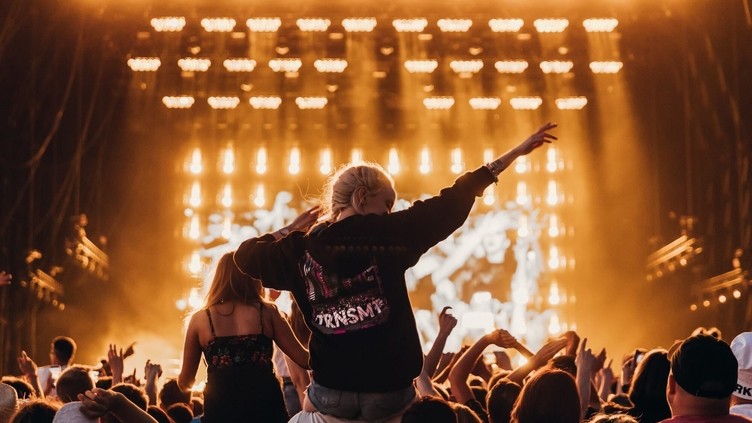 Girl sitting on the shoulders of a guy in the crowd at TRNSMT festival