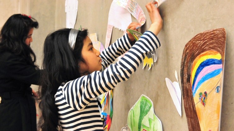 A group of children attaching drawings to a wall at the Nottingham Contemporary Art Gallery