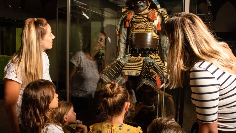 A group of people looking at a historic exhibition in RAMM, Exeter
