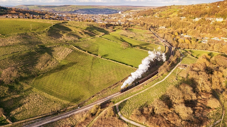 Steam train travelling along tracks in the countryside