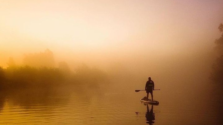 Someone paddling on the Broads, early morning