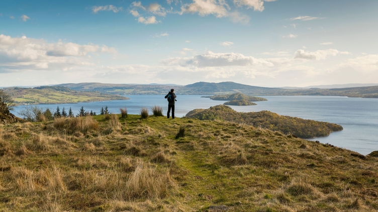 Walker taking in the view of Loch Lomond from Conic Hill part of the West Highland Way