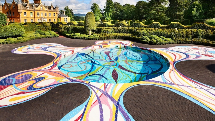 Ground pool sculpture in the landscape at Jupiter Artland with house and topiary gardens in distance