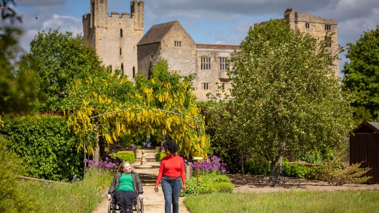 Two women walking through the garden, Helmsley Castle in the background