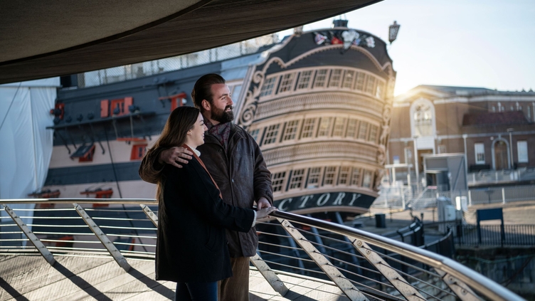 Two people looking over the bow of a ship
