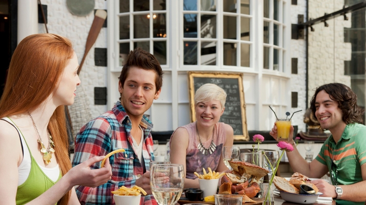 A group of people in a restaurant in Brighton, eating in the open air at Fishy Fishy restaurant.