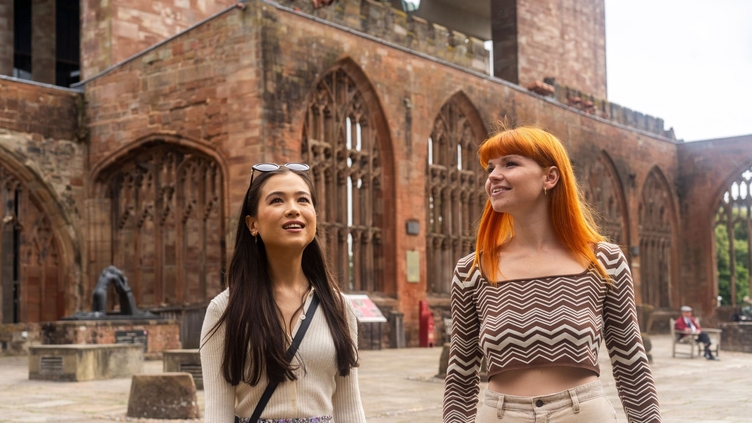 Deux femmes explorent les ruines dans la cour d'une cathédrale