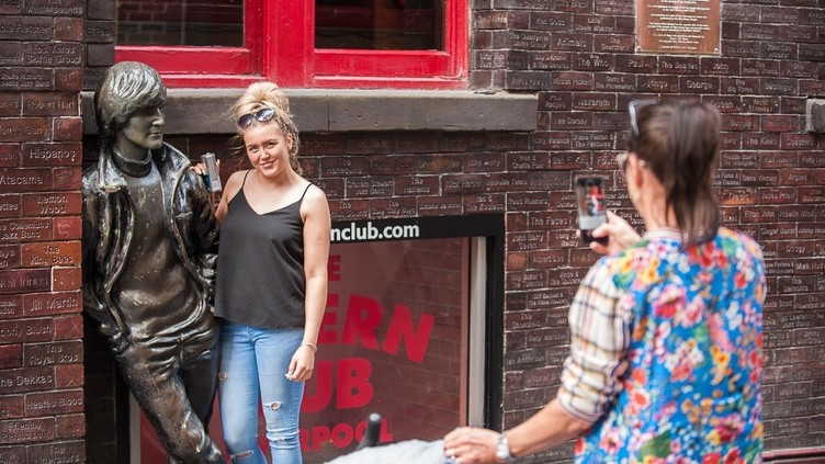 Una donna in posa fuori dal Cavern Club di Liverpool, un locale famoso nella storia dei Beatles