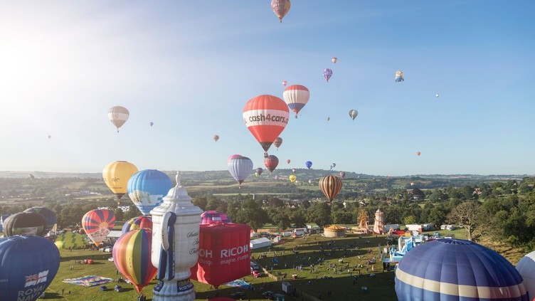 Colourful hot air balloons over floating above countryside