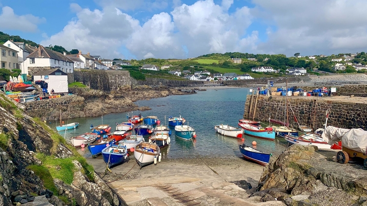 A quaint seaside village with moored boats and traditional housing.