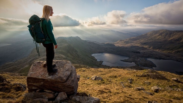 A young woman standing on rocks at a lookout point