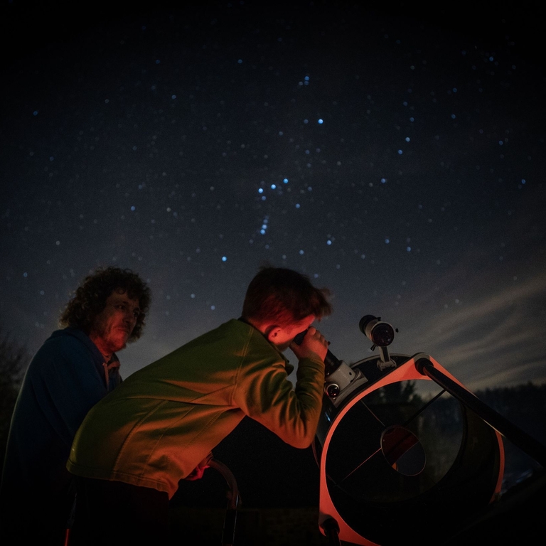 Child stargazing through telescope