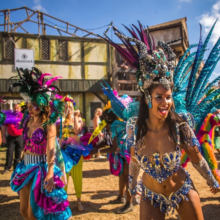 Women, in elaborate costumes, dancing at music festival