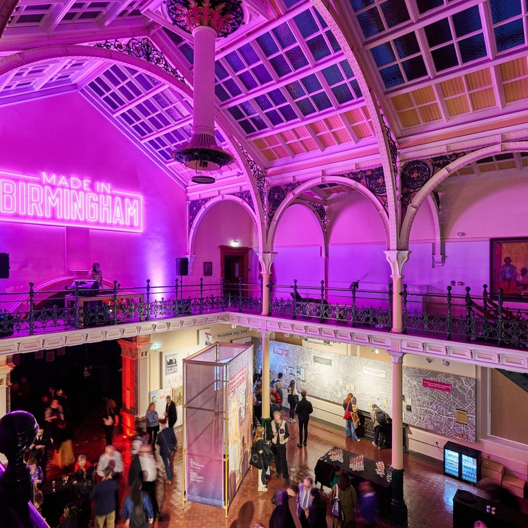 A museum gallery hall in pink light.