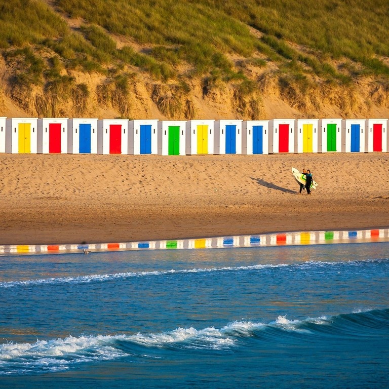 Idyllic Scene On Surfers Beach With Beautiful Beach Huts Reflecting In The Water
