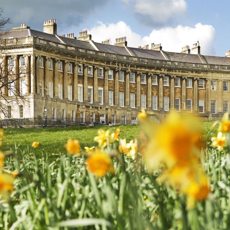 Vue extérieure, à travers un champ de jonquilles floues au premier plan, du Royal Crescent Hotel and Spa, Bath