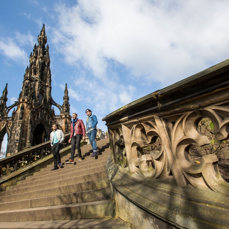 Three men walking down stone steps of a monument