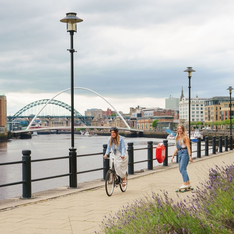 Two men skateboard along the River Tyne in Newcastle