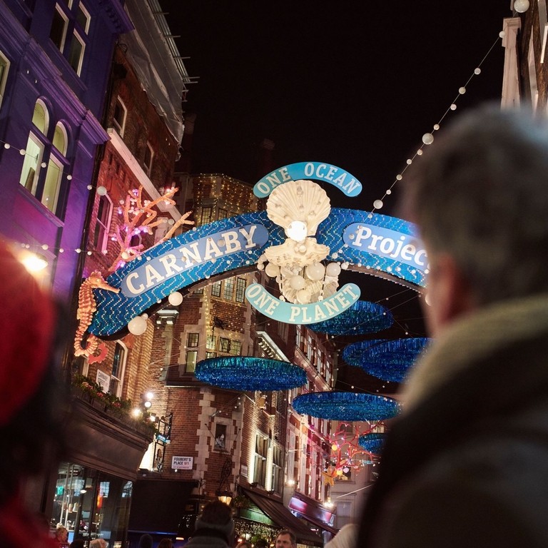 Couple walking down street under christmas lights