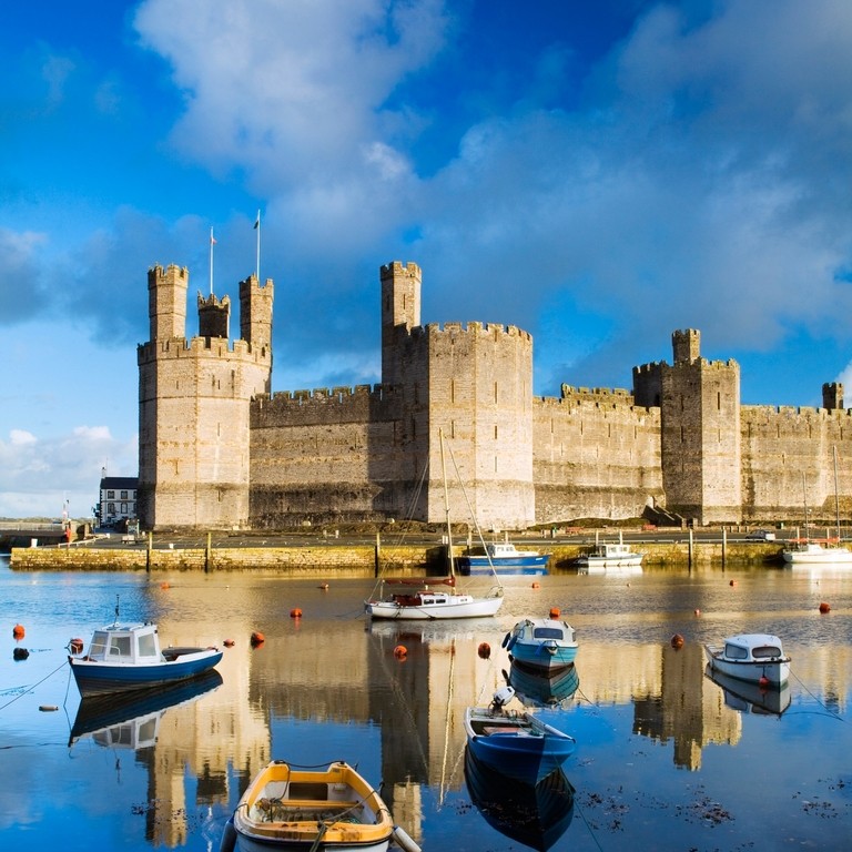 Row boats in a moat surrounding a castle