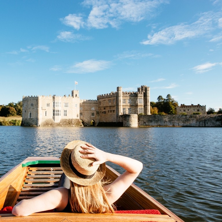 Eine Frau in einem Stechkahn auf dem Wassergraben mit Blick auf Leeds Castle