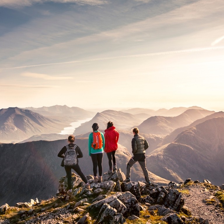 People standing on high point looking down at mountain view