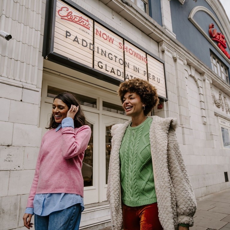 Two women leaving a retro cinema.