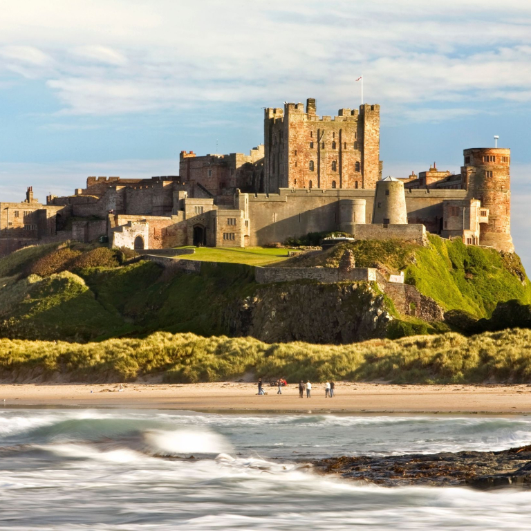 Vue de loin d'un château sur une colline près d'une plage