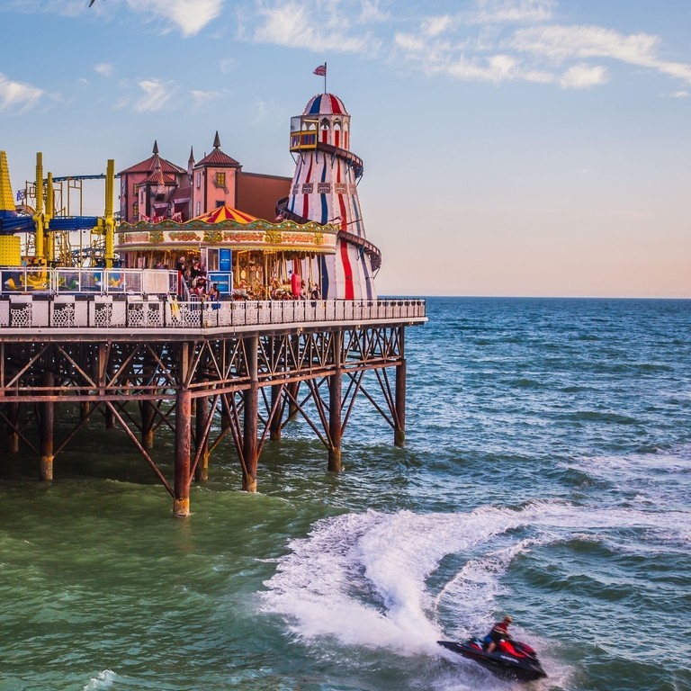 Moto d'acqua in mare sotto un molo balneare con luna park