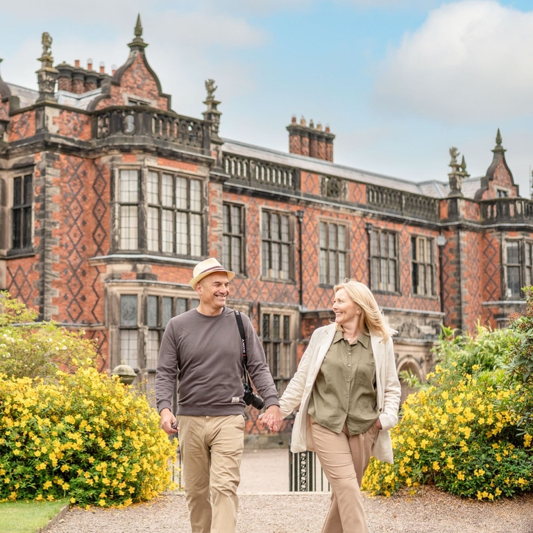 A man and a woman walk through the grounds of a heritage property