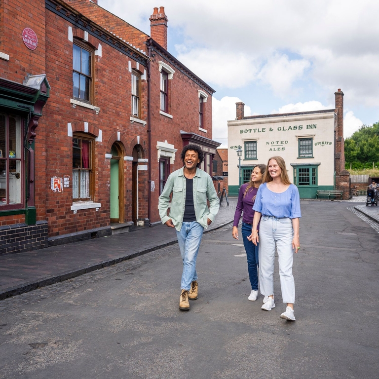 three friends explore the streets of a period living museum.