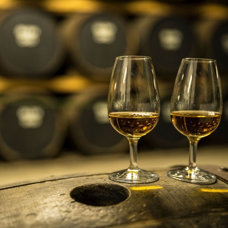 Due bicchieri di whisky in piedi su un barile di quercia