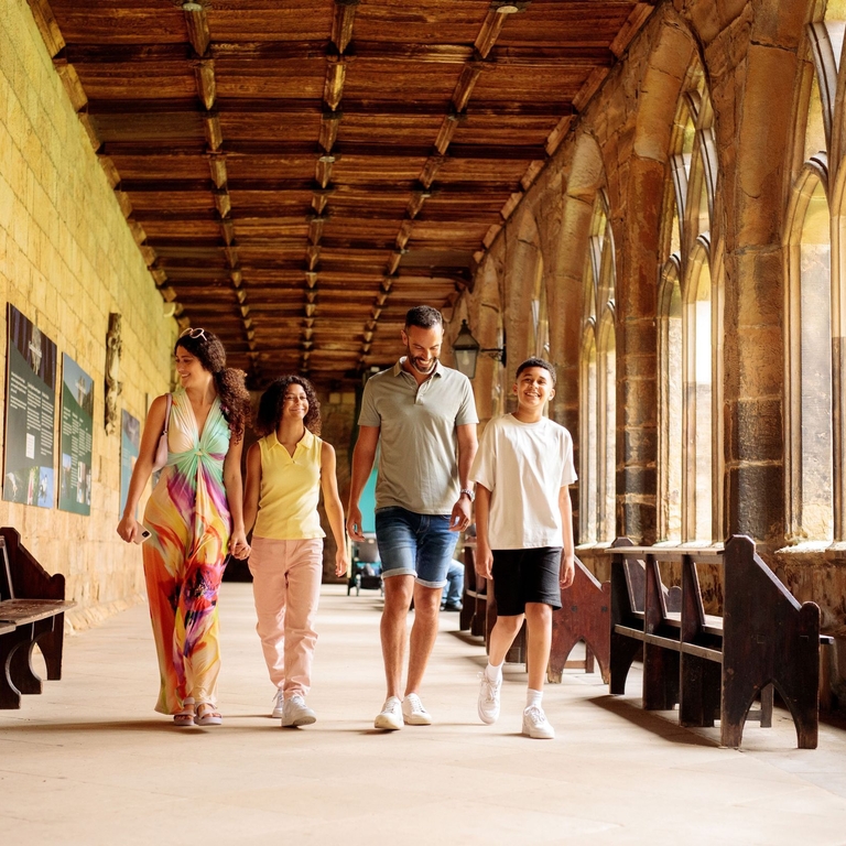 Family walking through the cloisters of a cathedral
