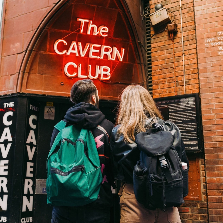 Man and woman standing on the street outside a club with sign reading: The Cavern Club