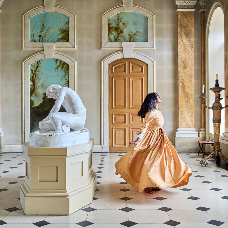 A woman dances in a gallery room at a heritage property
