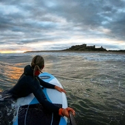 Blick auf eine Frau, die mit einem Paddleboard im Meer treibt