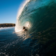 Surfeur surfant sur une vague géante en position accroupie
