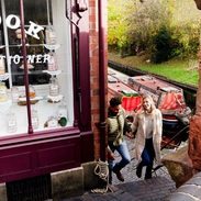 Couple walking up steps by the side of a sweet shop and canal