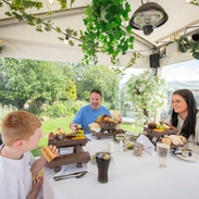 A father and two children eat lunch in a dining pod outside an Inn