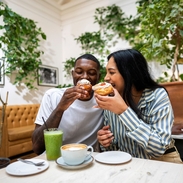 A man and a woman have cake and drinks in a cafe