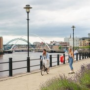 Two men skateboard along the River Tyne in Newcastle