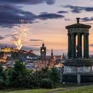 Fireworks at dusk in the sky over historic monument.