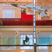 Male wheelchair user on elevated walkway at a museum