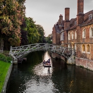 A single punt passes under the Mathematical bridge, in Silver street, Cambridge late on a summer's evening