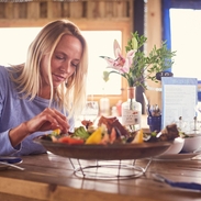 Mujer rubia y hombre sentados a la mesa, comiendo una fuente de marisco