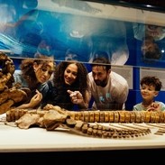 Family crouching to look at an animal skeleton on display