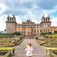 Woman walking in Blenheim Palace gardens surrounded by greenery