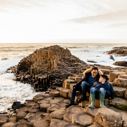 Man and boy sitting on the red basalt columns