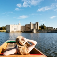 Eine Frau in einem Stechkahn auf dem Wassergraben mit Blick auf Leeds Castle